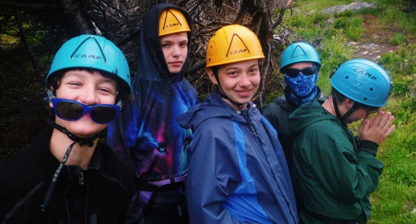 A group of young people wearing helmets pose for the photo. 